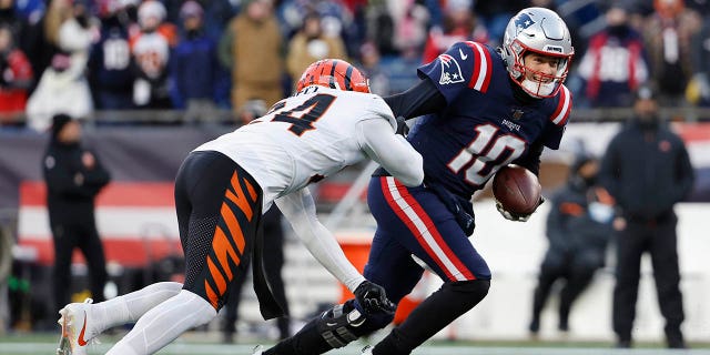 Vonn Bell # 24 des Bengals de Cincinnati fait pression sur Mac Jones # 10 des Patriots de la Nouvelle-Angleterre alors qu'il tente une passe au quatrième quart au Gillette Stadium le 24 décembre 2022 à Foxborough, Massachusetts.