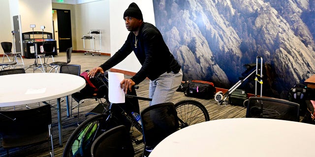 Colorado Buffaloes head football coach Deion Sanders rides a bicycle at a press conference on National Signing Day on February 1, 2023.