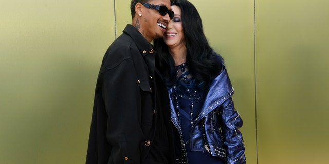 Alexander Edwards and Cher cuddled on the carpet at the Versace fashion show.