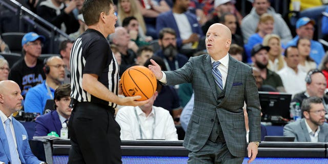 El entrenador en jefe de los UCLA Bruins, Mick Cronin, habla con un árbitro en la segunda mitad del juego del campeonato de baloncesto Pac-12 contra los Arizona Wildcats en T-Mobile Arena el 11 de marzo de 2023 en Las Vegas. Los Wildcats derrotaron a los Bruins 61-59.