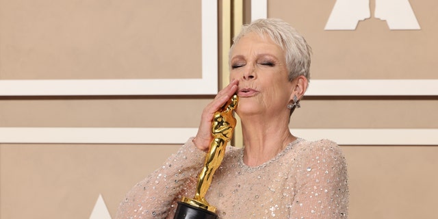 Jamie Lee Curtis proudly kisses her Oscar.