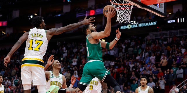 Jayson Tatum #0 dari Boston Celtics mencetak gol di depan Tari Eason #17 dari Houston Rockets selama babak kedua di Toyota Center pada 13 Maret 2023 di Houston, Texas. 
