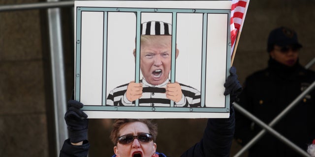 A demonstrator stands outside the Manhattan Criminal Court on March 21, 2023, ahead of an expected grand jury vote on whether to indict former President Donald Trump. 