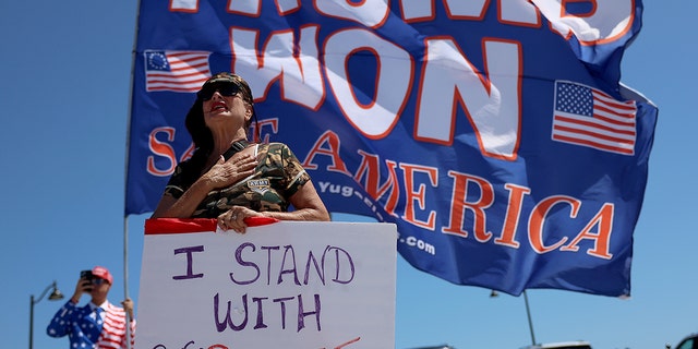 A Trump supporter shows her support for former President Trump amid reports of a potential indictment. Trump suggested he could be arrested on charges from the Manhattan DA, and called for Americans to "protest."