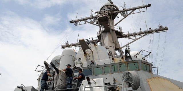 Navy sailors remove the cover of the Phalanx Close-In Weapon System of the USS Milius (DDG-69), a multi-mission capable guided missile destroyer ship docked at the Manila South Harbor on Aug. 18, 2012.