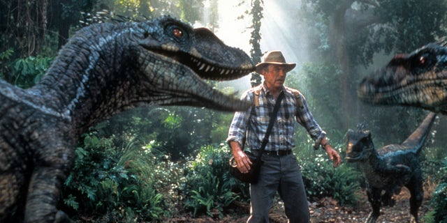 Neill is confronted by three dinosaurs in a scene from the 2001 film "Jurassic Park III."
