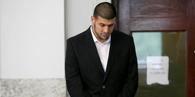 Aaron Hernandez estaba de pie en la sala del tribunal.  El ex ala cerrada de los New England Patriots, Aaron Hernandez, compareció ante el tribunal de distrito en Attleboro, Massachusetts, el miércoles 24 de julio de 2013. 