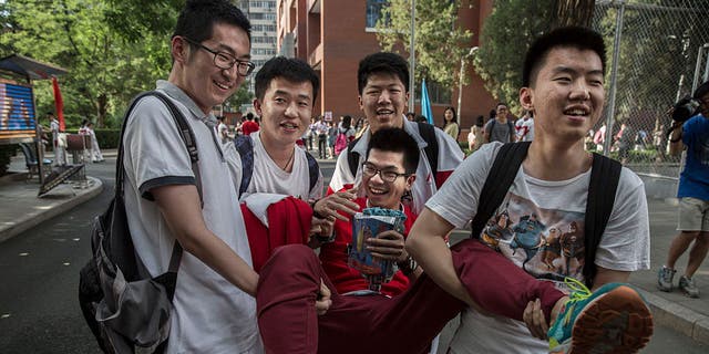 Siswa China bercanda satu sama lain saat mereka menggendong satu siswa setelah menyelesaikan Gaokao di Sekolah Menengah Atas Afiliasi Universitas Renmin Beijing pada 8 Juni 2015 di Beijing.  Siswa menghabiskan waktu berbulan-bulan untuk mempersiapkan ujian tahunan, dan ini juga merupakan waktu yang menegangkan bagi orang tua karena hasilnya menentukan jalur pendidikan siswa dan menentukan prospek pekerjaan di masa depan.  Lebih dari 9 juta siswa di seluruh China mengikuti ujian selama dua hari terakhir.