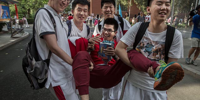 Chinese students joke with each other as they carry one student after completing the Gaokao at the Beijing Renmin University Affiliated High School on June 8, 2015 in Beijing. Students spend months preparing for the annual exam, and it is also a stressful time for parents as the results determine a student's educational path and dictates future job prospects. More than 9 million students across China took the test over the last two days.