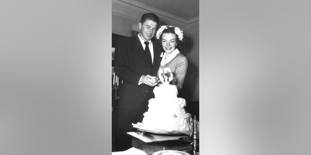 Ronald Reagan and Nancy Reagan, just married, cut their wedding cake following their marriage ceremony.