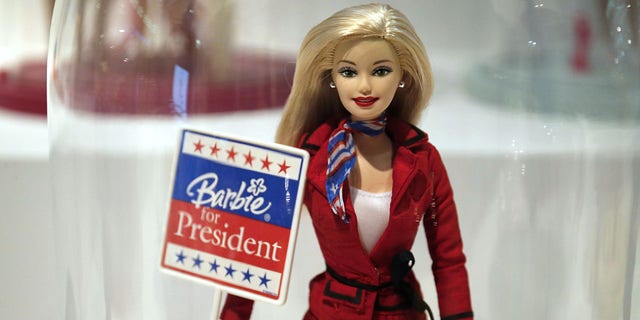 A photo taken on March 10, 2016, in Paris shows a Barbie doll holding an election-related poster reading 