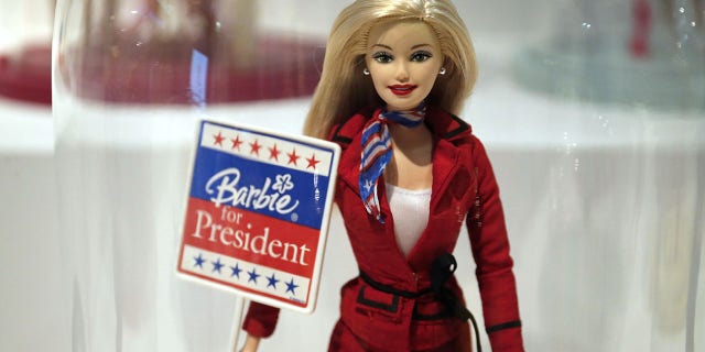 A photo taken on March 10, 2016, in Paris shows a Barbie doll holding an election-related poster reading 