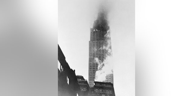 A striking view of the giant Empire State Building with its upper stories enveloped in smoke and flame after it was rammed by a U.S. Army B-25 bomber.