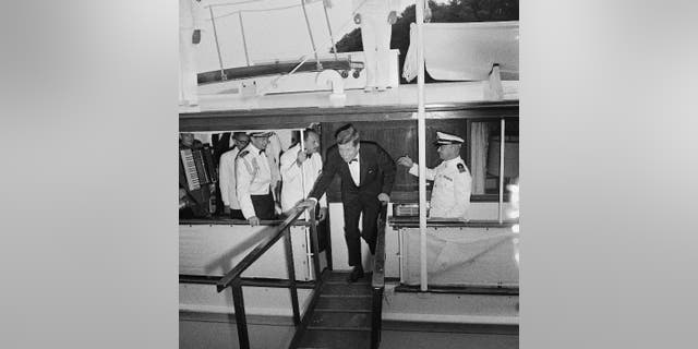 President Kennedy, followed by Pakistan President Mohammed Ayub Khan, leaves his yacht, Honey Fitz upon arrival at Mount Vernon.