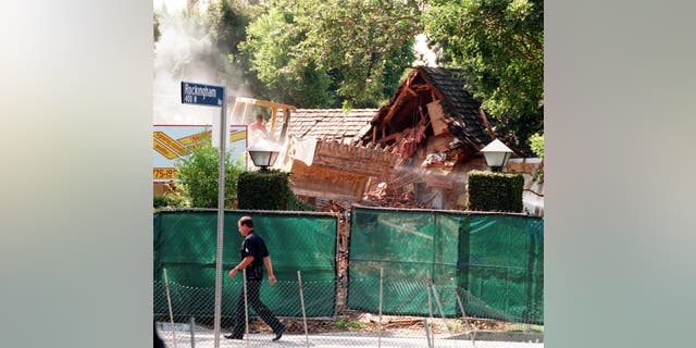 A bulldozer tears down the former residence of ex-football star O.J. Simpson on July 28, 1998, in Brentwood, California.