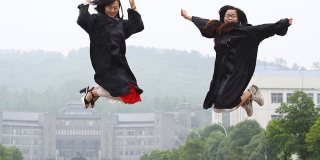 Femle students pose for graduating photograph at a university in Xiangyang, Hubei province, China on June 3, 2015.