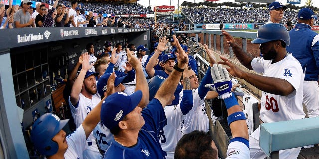 Los Angeles Dodgers' Andrew Toles (60) celebrates with teammates in the eighth inning after scoring during Game 4 of the National League Division Series against the Washington Nationals at Dodger Stadium on October 11, 2016 in Los Angeles.  