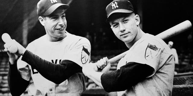 New York Yankees sluggers Joe DiMaggio and Mickey Mantle posing for the camera with their pine bats, 1951.