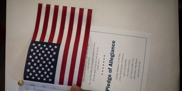 A candidate for US citizenship holds a US flag during a naturalization ceremony for new US citizens February 16, 2017 in Newark, New Jersey.