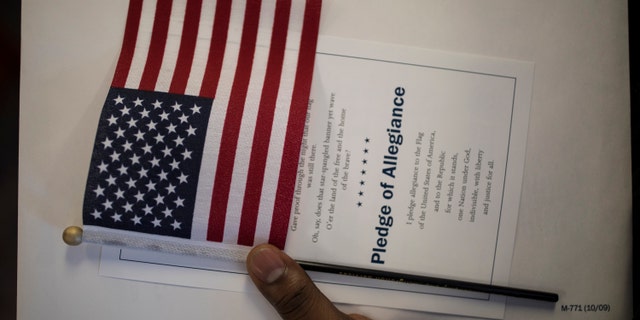 A candidate for US citizenship holds a US flag during a naturalization ceremony for new US citizens February 16, 2017 in Newark, New Jersey.
