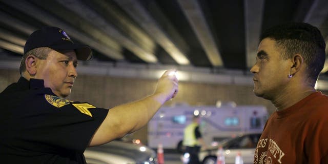 Sergeant Luis Taborda from the City of Miami police department conducts a field sobriety test at a DUI checkpoint