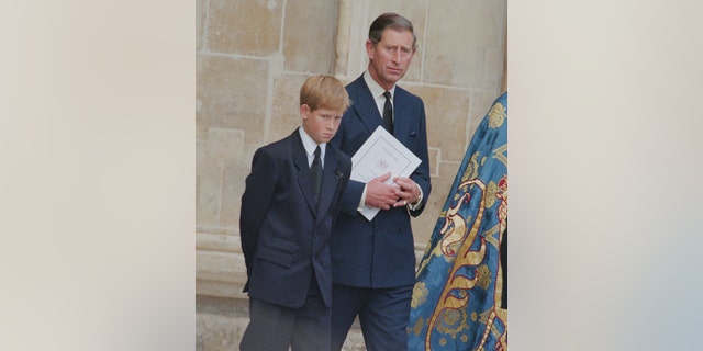 Prince Harry and the now King Charles are photographed at Diana's funeral service at Westminster Abbey in 1997.