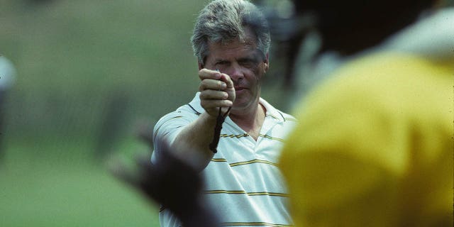 El gerente de personal de los Pittsburgh Steelers, Dick Haley, usa un cronómetro para cronometrar a los jugadores en la carrera de 40 yardas en el campo de entrenamiento de verano de St. Vincent College en julio de 1991 en Latrobe, Pensilvania.