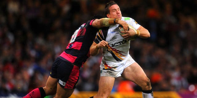 Bradford Bulls' Bryn Hargreaves is tackled by Leeds Rhinos' Kyle Leuluai (left) during the Engage Super League match at the Millennium Stadium, Cardiff.