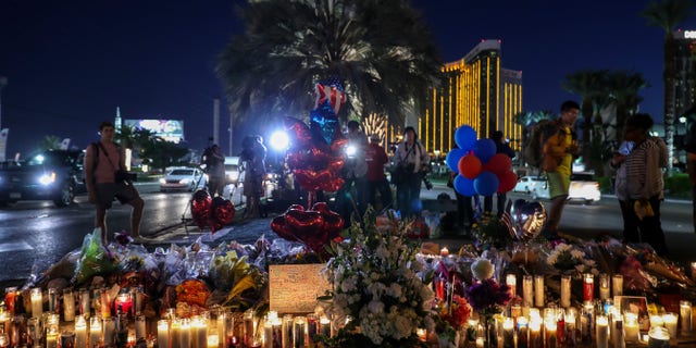 People light candles, place figures and flowers at a makeshift memorial set up along the Las Vegas Strip for the Las Vegas mass shooting victims, who lost their lives after a gunman attack, on Oct. 5, 2017, in Las Vegas.