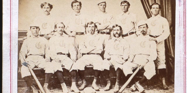 The 1869 Cincinnati Red Stockings, the first professional baseball team, are featured on the front of a Sporting Goods trade card from Peck & Snyder of New York City. In the photo are captain Harry Wright, front row, center, George Wright, back row second from left, and in the back row, second from right is catcher Cal McVey.