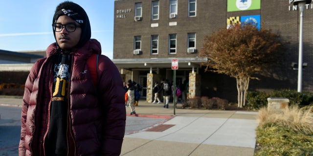 Student stands outside of a Baltimore City high school