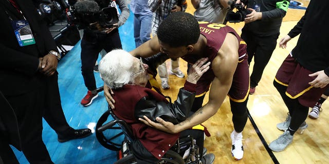 Aundre Jackson (24) of the Loyola Ramblers celebrates with Sister Jean Dolores Schmidt after defeating the Nevada Wolf Pack during the 2018 NCAA men's basketball tournament South regional at Philips Arena March 22, 2018, in Atlanta.  