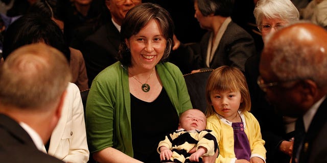 Ann O'Leary, istri University of California di Berkley Law Profesor Goodwin Liu, menggendong putra mereka yang berusia 1 bulan Emmett dan duduk bersama putri mereka, Violet, 3, sebelum sidang konfirmasi Liu untuk menjadi Hakim Sirkuit AS untuk Sirkuit Kesembilan sebelum sidang Komite Kehakiman Senat 16 April 2010 di Washington, DC.