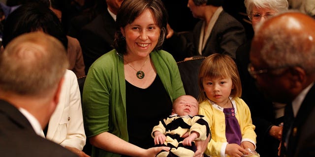 Ann O'Leary, istri University of California di Berkley Law Profesor Goodwin Liu, menggendong putra mereka yang berusia 1 bulan Emmett dan duduk bersama putri mereka, Violet, 3, sebelum sidang konfirmasi Liu untuk menjadi Hakim Sirkuit AS untuk Sirkuit Kesembilan sebelum sidang Komite Kehakiman Senat 16 April 2010 di Washington, DC.