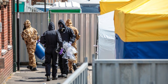 Emergency workers in protective suits search an area after a man and woman were exposed to the Novichok nerve agent on July 6, 2018, in Salisbury, England.