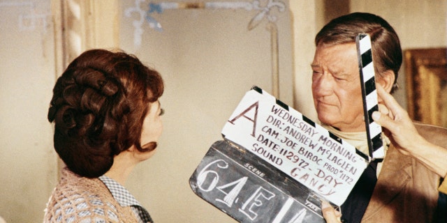 Marie Windsor and John Wayne filming a scene