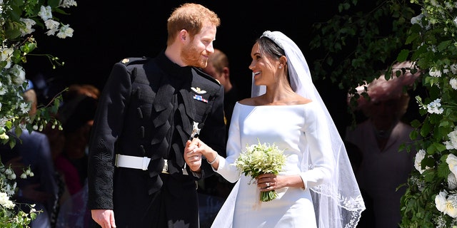 Prince Harry and Meghan Markle smiling and staring at each other on their wedding day