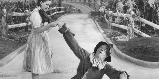 Ray Bolger as The Scarecrow in "The Wizard of Oz" alongside Judy Garland.