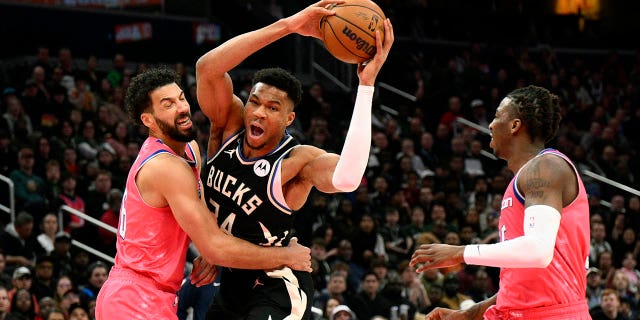 L'attaquant des Milwaukee Bucks Giannis Antetokounmpo est victime d'une faute de l'attaquant des Washington Wizards Anthony Gill, à gauche, au cours de la première moitié d'un match de basket de la NBA, le dimanche 5 mars 2023, à Washington, DC Le garde des Wizards Delon Wright est à droite.