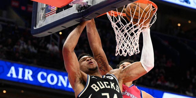 Milwaukee Bucks forward Giannis Antetokounmpo, #34, dunks past Washington Wizards forward Anthony Gill, #16, during the first half of an NBA basketball game, Sunday, March 5, 2023, in Washington, D.C.
