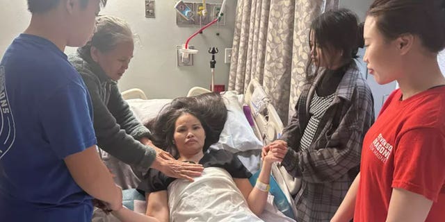 Nhung Truong paralyzed in a hospital bed with her mother and children surrounding her after being attacked by a robber in Houston, Texas.