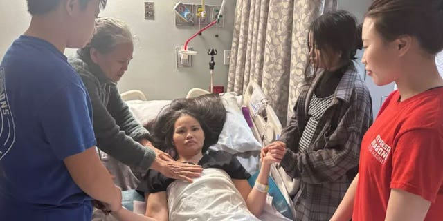 Nhung Truong paralyzed in a hospital bed with her mother and children surrounding her after being attacked by a robber in Houston, Texas.