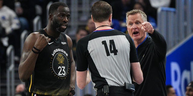 El entrenador en jefe de los Golden State Warriors, Steve Kerr, y Draymond Green #23 intercambian palabras con el árbitro Ed Malloy durante el segundo cuarto contra los New Orleans Pelicans en el Chase Center el 28 de marzo de 2023 en San Francisco, California.