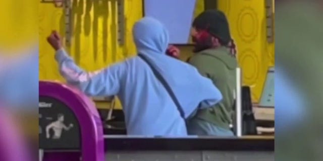An attacker is seen in a blue sweatshirt holding a knife at a Planet Fitness gym in California.