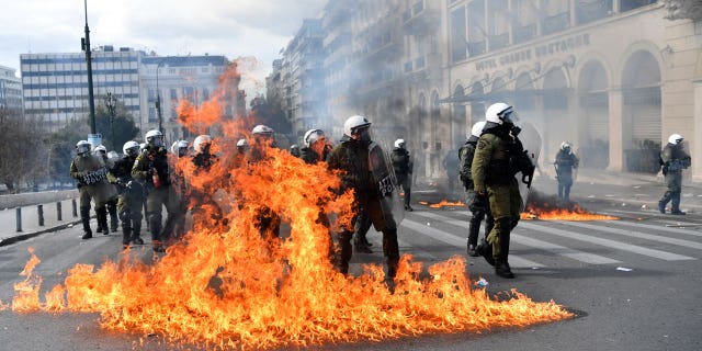 Huelgas, protestas y enfrentamientos por fatal accidente de tren en Grecia 4 La policía antidisturbios toma posición junto a las llamas de cócteles Molotov después de que los manifestantes fueran arrojados durante una huelga general de 24 horas en el centro de Atenas, el 16 de marzo de 2023.