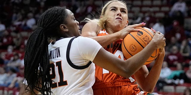 Haley Cavinder, #14, de Miami, es defendida por Terryn Milton, #21, de Oklahoma State, en la primera mitad de un partido de baloncesto universitario de primera ronda en el Torneo Femenino de la NCAA el sábado 18 de marzo de 2023, en Bloomington, Indiana.