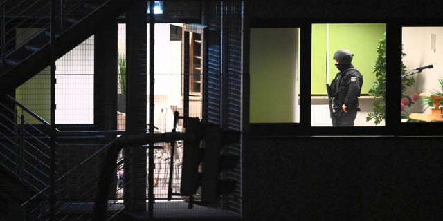 Police officers in special equipment walk through a Jehovah's Witness building in Hamburg, Germany, Thursday, March 9, 2023. 