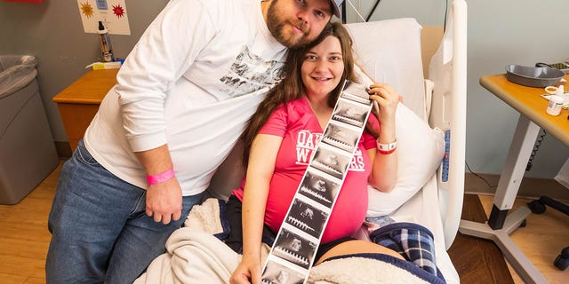 Shawn and Haylee Ladner of Purvis smile with some of their quintuplets' first "photos" — images from a sonogram.