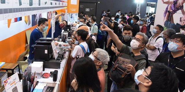 People wearing face masks shop for Solid State Drive (SSD) during the 2021 Hong Kong Computer and Communications Festival at Hong Kong Convention and Exhibition Center on August 20, 2021 in Hong Kong, China.