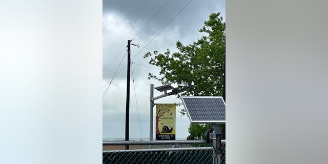 A flag at a site next to a Boring Co. facility in Bastrop, TX, reads "welcome, snailbrook, tx, est. 2021."